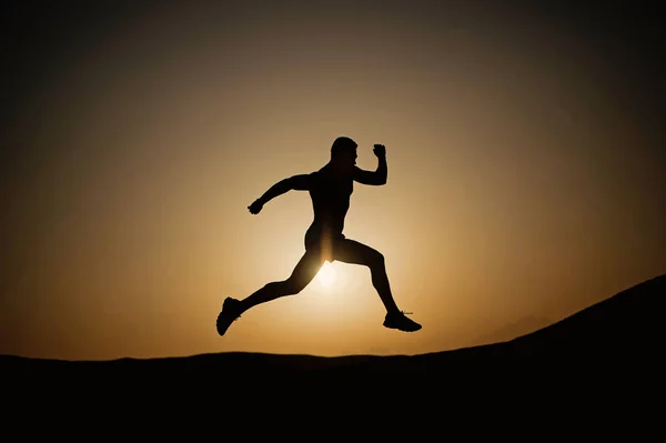 Running man silhouette at sunset sky — Stock Photo, Image