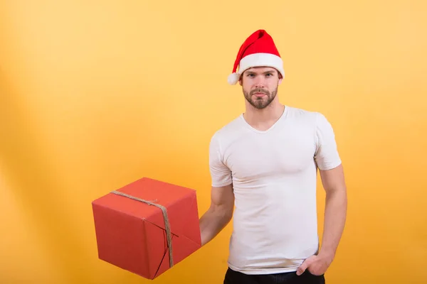 Homme au chapeau de Père Noël tenir cadeau de Noël. Le matin avant Noël. heureux père Noël homme sur fond jaune. livraison cadeaux de Noël. achats de Noël en ligne. Bonne année, copiez l'espace. Amusement de Noël — Photo