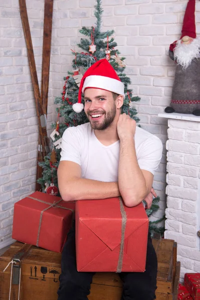 Delivery christmas gifts. The morning before Xmas. man in santa hat hold christmas present. happy santa man. online christmas shopping. New year scene with tree and gifts. Merry Christmas. Happiness — Stock Photo, Image