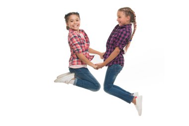 En iyi arkadaş kıyafeti. Kız arkadaşlar benzer kıyafetler giyer. Aynı saç stili kanekalon örgüleri vardır. Beyaz arka plan. Kız kardeşler gibi giyinmiş. En iyi arkadaşınla benzer giyin. Arkadaşına uygun giyin.