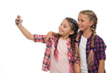 Küçük şirin kızlar telefon ekranına gülümsüyor. Sosyal ağlar için selfie çekmeyi seviyorlar. Genç nesil sorunu. Cep telefonu bağımlılığı. Cep telefonu ve internet bağımlılığı veya saplantı