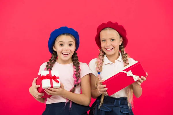 Pequenas meninas bonitos receberam presentes de férias. Traga felicidade para as crianças. Os melhores presentes para crianças. Crianças meninas em uniforme escolar e boinas segurar caixas de presentes. Crianças animadas com presentes de desembalagem — Fotografia de Stock