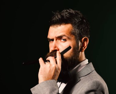 Uzun sakallı bir adam tıraş bıçağı tutar..