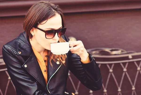 Menina em óculos de sol bebe café saboroso no fundo terraço marrom — Fotografia de Stock