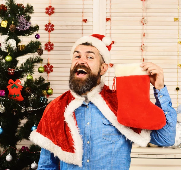 Ragazzo in cappello e mantello rosso e bianco tiene calza — Foto Stock