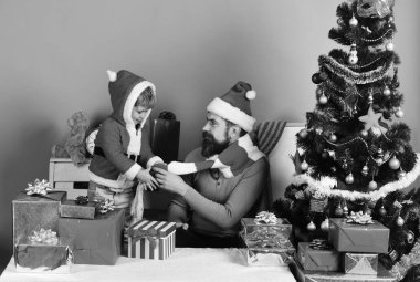 Noel ailesi hediyeleri mavi arka planda açar.