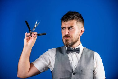 Vintage sanat kavramı berber. Kuaför keskin ustura ile tıraşsız hippi. Berber Kuaför Salonu. İpuçları bakım Kuaför sakal. Erkek yelek papyon ile tutun usturanın mavi arka plan