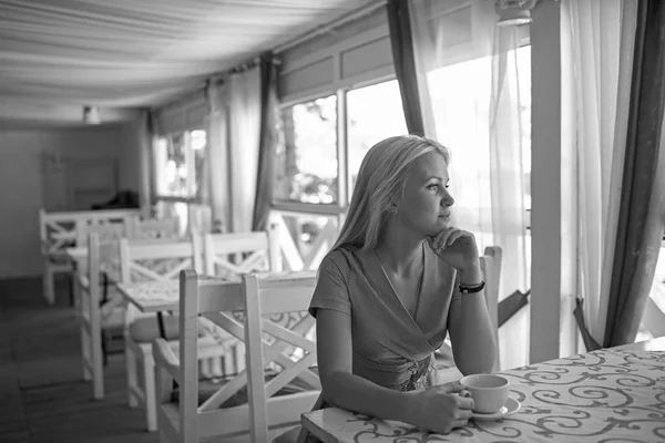 Girl drinks coffee or tea in cafe or restaurant.