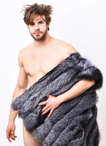 Sexy slaperig rijke macho tousled haar vacht vest op witte achtergrond. Mode en pathos. Guy aantrekkelijke fotomodel poseren bontjas op naakte lichaam. Rijkdom en luxe levensstijl. Fashion concept — Stockfoto