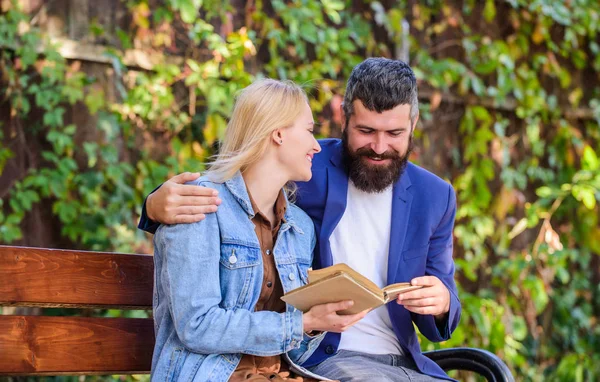 Read same book together. Couple interested literature. Literature common interest. How to find girlfriend with common interest. Meeting people with similar interests. Man and woman sit bench park