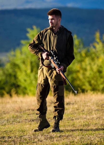 Hunter with rifle looking for animal. Hunting shooting trophy. Mental preparation for hunting individual process. Man rifle for hunt. Hunter khaki clothes ready to hunt hold gun mountains background — Stock Photo, Image