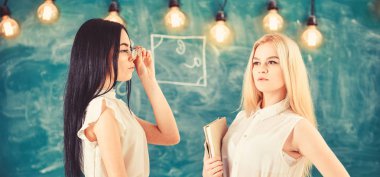 Çekici öğretmen sınıfları sonra overworking. Bayanlar özel ders, kara tahta arka plan başlamak için hazır. Kitap ve çekici görünümlü gözlük ile formal giyim öğretmenler. Özel ders kavramı