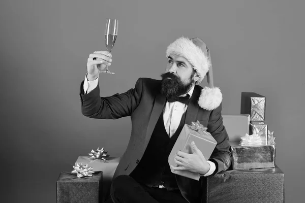 A szakállas férfi megtartja az ajándékot és a pezsgőt — Stock Fotó