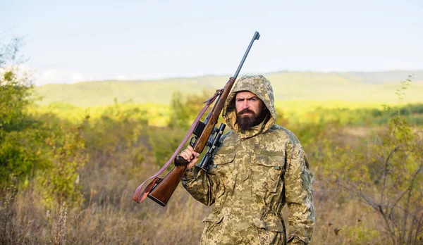 Hunting season. Guy hunting nature environment. Bearded hunter rifle nature background. Hunting big game typically requires tag each animal harvested. Experience and practice lends success hunting — Stock Photo, Image