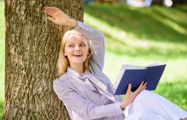 Kız ağaç üzerinde yalın park sit çimenlerde rahatlayın. Kendini geliştirme kitabı. İş Bayan bul dakika kitap okumayı geliştirmek onun bilgisi. Kendini geliştirme ve eğitim kavramı. Kadın kendini geliştirme