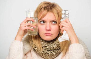 Hızlı yardım alma. Daha iyi hissetmek için yollarını hızlı. Grip ilaçları evde. Bayan giyimi sıcak eşarp çünkü hastalık veya grip. Kız tutun cam su tabletleri ve termometre açık renkli yakın çekim. Gribi ile kurtulmak