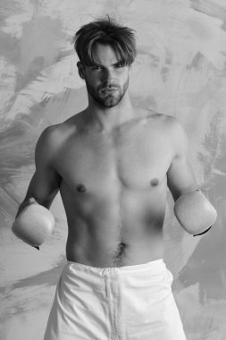 Spor ve savaş. Adam çıplak gövde ile boks eldiven giyer