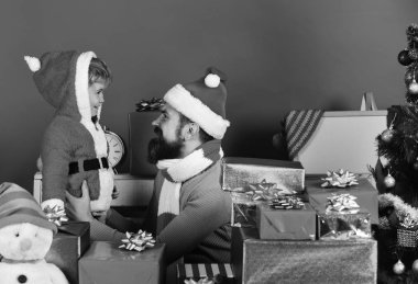 Sakallı ve gülen yüzlü bir adam oğluyla oynuyor.