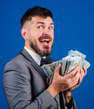 Nakit kolay ve hızlı bir şekilde olsun. Nakit işlem iş. Adam mutlu kazanan zengin doları banknot yığını mavi arka plan tutun. Kolay nakit krediler. İşadamı nakit para var. Piyango kavramı kazanmak