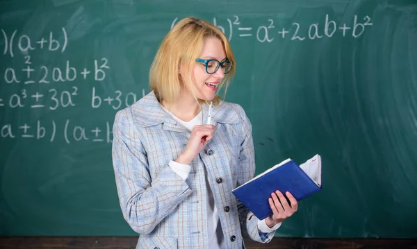 El profesor de escuela explica bien las cosas y hace que el tema sea interesante. La enseñanza efectiva implica la adquisición de conocimientos relevantes sobre los estudiantes. Maestra mujer explicar cerca de pizarra. Lo que hace gran maestro — Foto de Stock