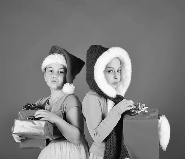 Noel Baba şapkalı kız kardeşler hediyelerini alıyorlar.. — Stok fotoğraf