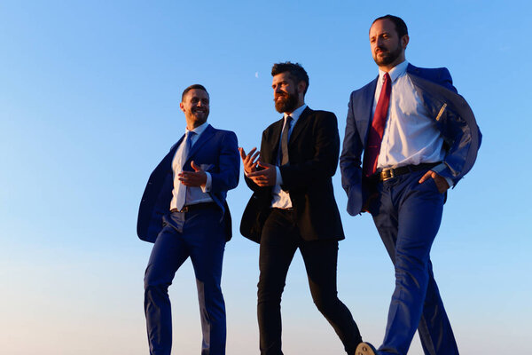 Company leaders take a walk on sunset sky background