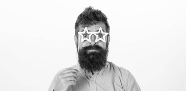 Pembe gömlekli beyaz arka plan üzerinde izole şık sakallı hippi. Sakallı yakışıklı kağıt yıldız şeklinde gözlük, eğlenceli bir konsept. Sakallı adam Doğum günü parti aksesuarları ile poz