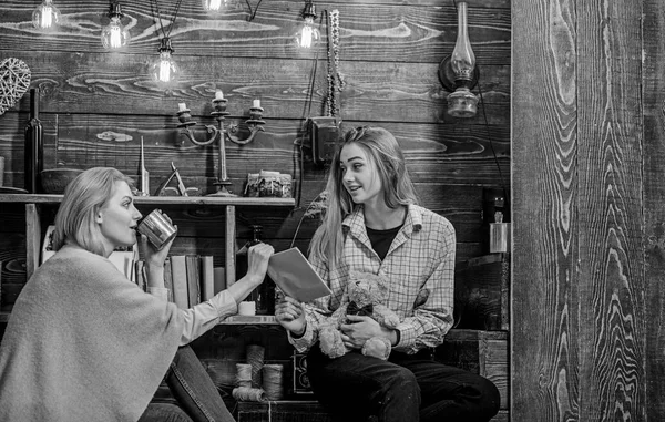 Mujer tomando té mientras conversaba con su hija. Mamá mostrando el viejo libro o álbum familiar a la adolescente, tradiciones y concepto de historia. Vacaciones familiares en el campo casa de madera — Foto de Stock