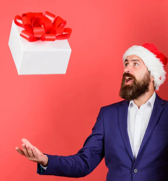 Gift box with festive ribbon bow falling right to male hand. Quick gift delivery. Gift service concept. Send or receive christmas present. Man bearded hipster formal suit happy celebrate christmas