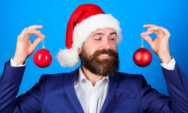 Biznesmen Dołącz do uroczystości Bożego Narodzenia. Santa przytrzymaj ozdoba piłka Boże Narodzenie. Wesołych Świąt Bożego Narodzenia. Świąteczną atmosferę wokół. Wakacje, przeznaczona dla zabawy. Brodaty mężczyzna nosić garnitur formalne i santa hat — Zdjęcie stockowe