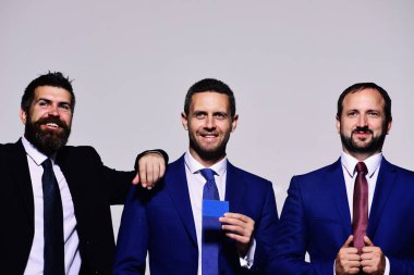 Gri arka planda resmi takım elbiseli gülen iş adamları..