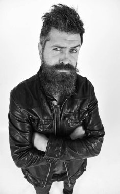 Sakal ve bıyık kameraya bakarak sıkı yüzünde olan adam. Maço deri ceket, beyaz arka plan giyer. Hipster şık kıyafetiyle poz ciddi görünüyor. Erkek Giyim ve moda kavramı