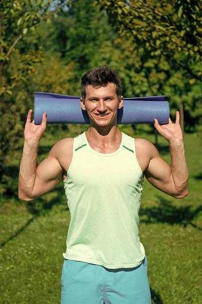 Heureux athlète souriant avec tapis de yoga bleu dans les mains — Photo