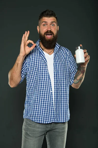 hipster man with vitamins. ok. healthy hair. Male barber care. Confident and handsome Brutal man. Bearded man. Mature hipster with beard. Hair and beard care. Confident in his choice. surprise.