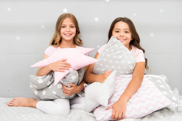 Girls happy best friends or siblings in cute stylish pajamas with pillows sleepover party. Sisters play pillows bedroom party. Pillow fight pajama party. Evening time for fun. Sleepover party ideas — Stock Photo, Image