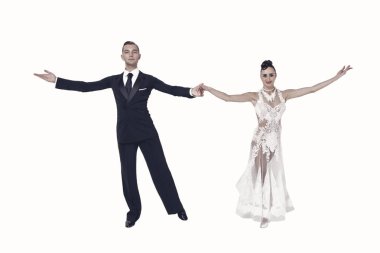 Dans eden balo çifti beyaz sahilde yalnız poz veriyor.