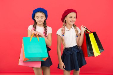 Alışveriş ve giyim alışveriş merkezleri ile saplantı. Alışverişkoliğin kavramı. Alışveriş bağımlısı olan işaretler. Çocuklar sevimli kız öğrenciler grup alışveriş torbaları tutun. Çocuk öğrenciler kırmızı arka plan alışveriş tarafından memnun