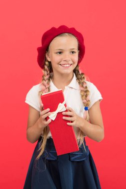 Çocuk küçük kız okul üniforması ve bere hediye kutusu tutun. Çocuk/açma hediye hakkında heyecanlı. Küçük sevimli kız alınan tatil hediye. Mutluluk yaymak. Çocuklar için en iyi hediye. Mutlu çocukluk anları
