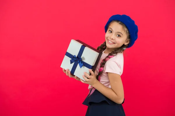 Zgadywać co Twoje marzenie dziecka. Najlepsze zabawki i prezenty świąteczne. Dziecko dziewczynka w beret kapelusz trzymać pudełko. Dziecko podekscytowany rozpakowanie prezent. Małe słodkie dziewczyny otrzymały gift pack z wstążka łuk — Zdjęcie stockowe