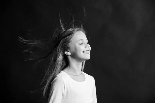 Cabello natural. Niña de pelo largo volando en el aire, fondo negro. Niño con hermoso peinado sano natural. Producto extremadamente eficaz. Consejos rápidos para un rizo saludable. Creciente recomendación para el cabello — Foto de Stock