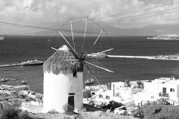 Windmill on seascape in Mykonos, Greece. Windmill on mountain by sea on sky. Whitewashed building with sail and straw roof with nice architecture. Summer vacation on island. Landmark and attraction — Stock Photo, Image