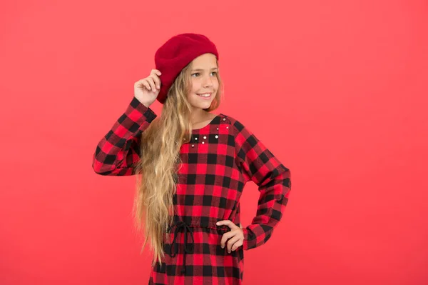Beret stilinspiration. Hur att bära basker som mode flicka. Kid lite söt tjej med långt hår poserar i hatt röd bakgrund. Fashionabla beret tillbehör för kvinna. Hur man bär franska beret — Stockfoto