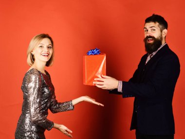 Kırmızı arka planda duran mutlu genç çift.