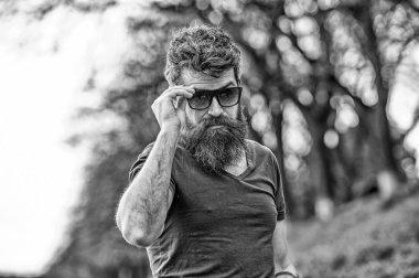 Adam ile şık güneş gözlüğü iyi görünüyor. Gözlüklü adam sakal ve bıyık giyer, ufuk arka plan. Hippi moda güneş gözlüğü ile kendine güvenen yüzünde. Göz koruma kavramı