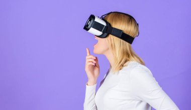 Dijital aygıt ve modern olanakları. Kadın başa takılı ekran menekşe arka plan. Sanal gerçeklik ve gelecekteki teknolojileri. Kız kullanım modern teknoloji vr kulaklık. Alternatif gerçeklik etkileşim