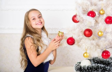 Yeni gelecek yıl hakkında heyecanlı neşeli evlat. Aile tatil kavramı. Küçük kız giyim kadife elbise Noel ağacının yanında şenlikli hissediyor. Noel çok özel mevsimde. Noel tezahürat yayılan
