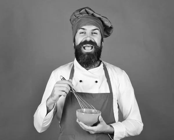 Hombre o hipster con barba sostiene utensilios de cocina sobre fondo verde. —  Fotos de Stock