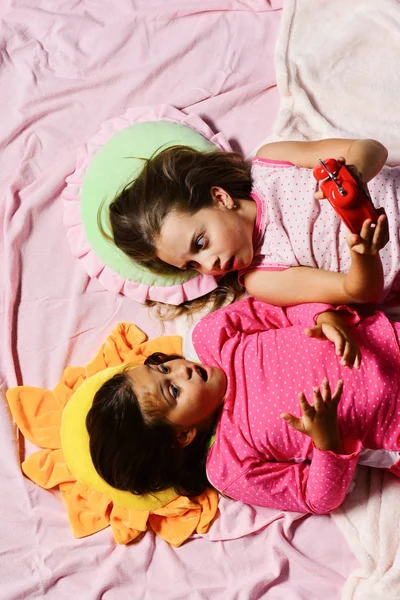 Schulmädchen in rosa Pyjamas liegen auf bunten Kissen, Draufsicht — Stockfoto