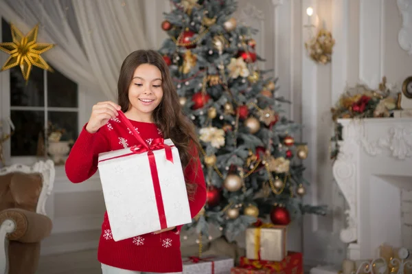 Kind meisje houdt xmas aanwezig. De ochtend voor Xmas. Nieuwjaars vakantie. Kerstmis. Kind geniet van de vakantie. Gelukkig Nieuwjaar. kleine gelukkig meisje met Kerstmis. Kerstmis fun. Feest van Kerstmis — Stockfoto