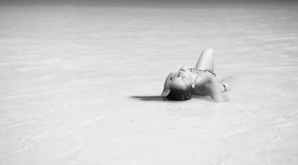 Delizia paradisiaca. Ragazza bikini sexy laici rilassante laguna di acqua turchese oceano. Donna in vacanza rilassante in acque paradisiache dell'oceano. Beach resort acqua cristallina luogo idilliaco. Relax totale — Foto Stock
